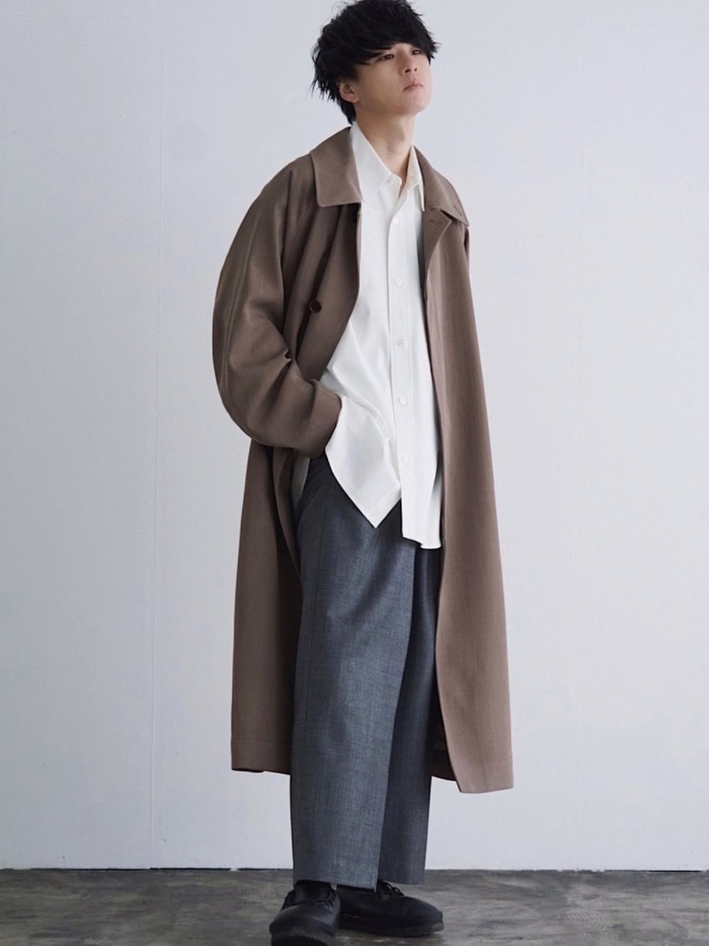 ブラウン系のステンカラーコート、ホワイト系のシャツ/ブラウス、グレー系のスラックスを着用したメンズの冬コーディネートの1枚目の写真