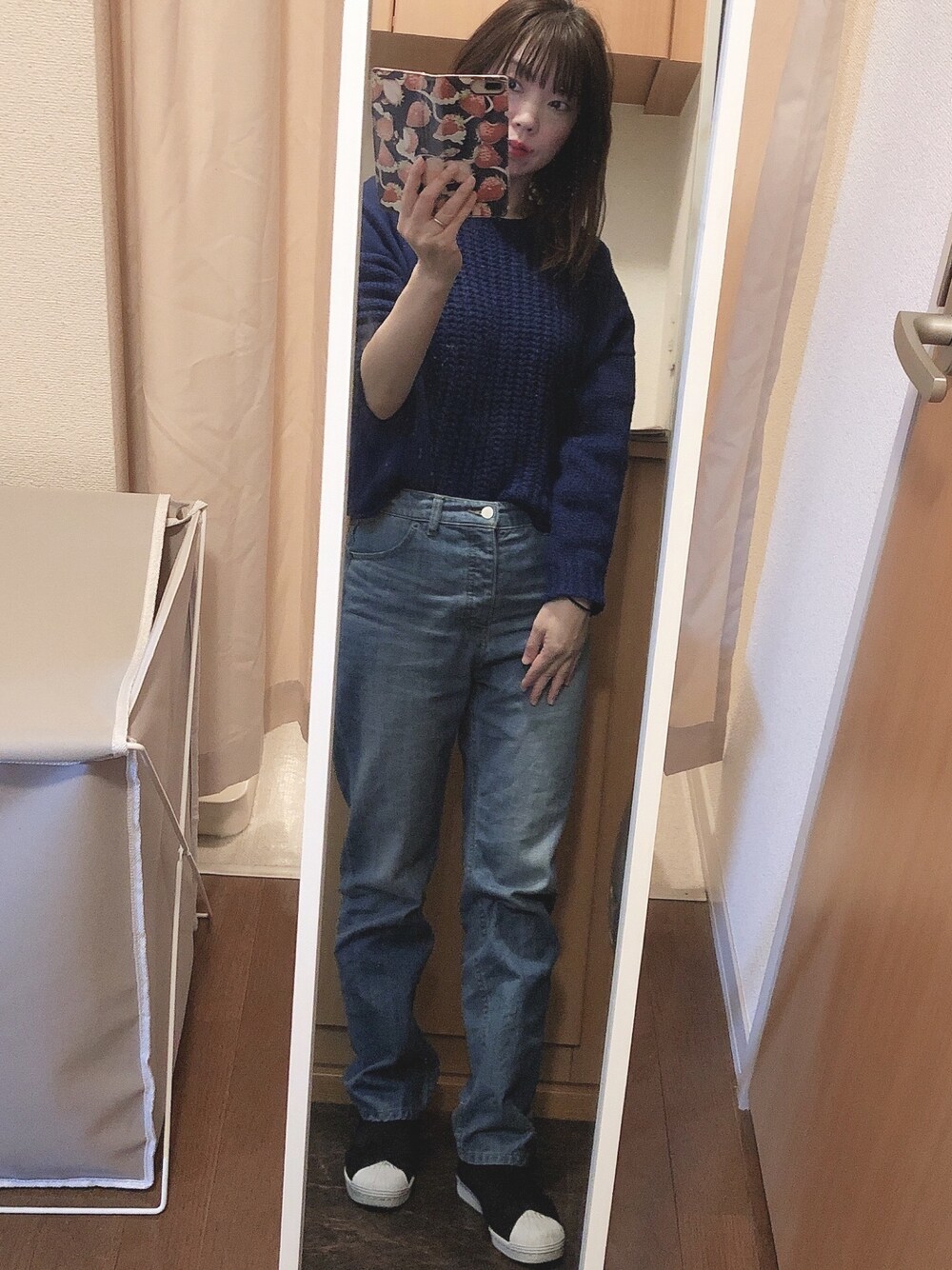 ブルー系のニット/セーター、ブルー系のデニムパンツ、ブラック系のスニーカーを着用したレディースの冬コーディネートの1枚目の写真