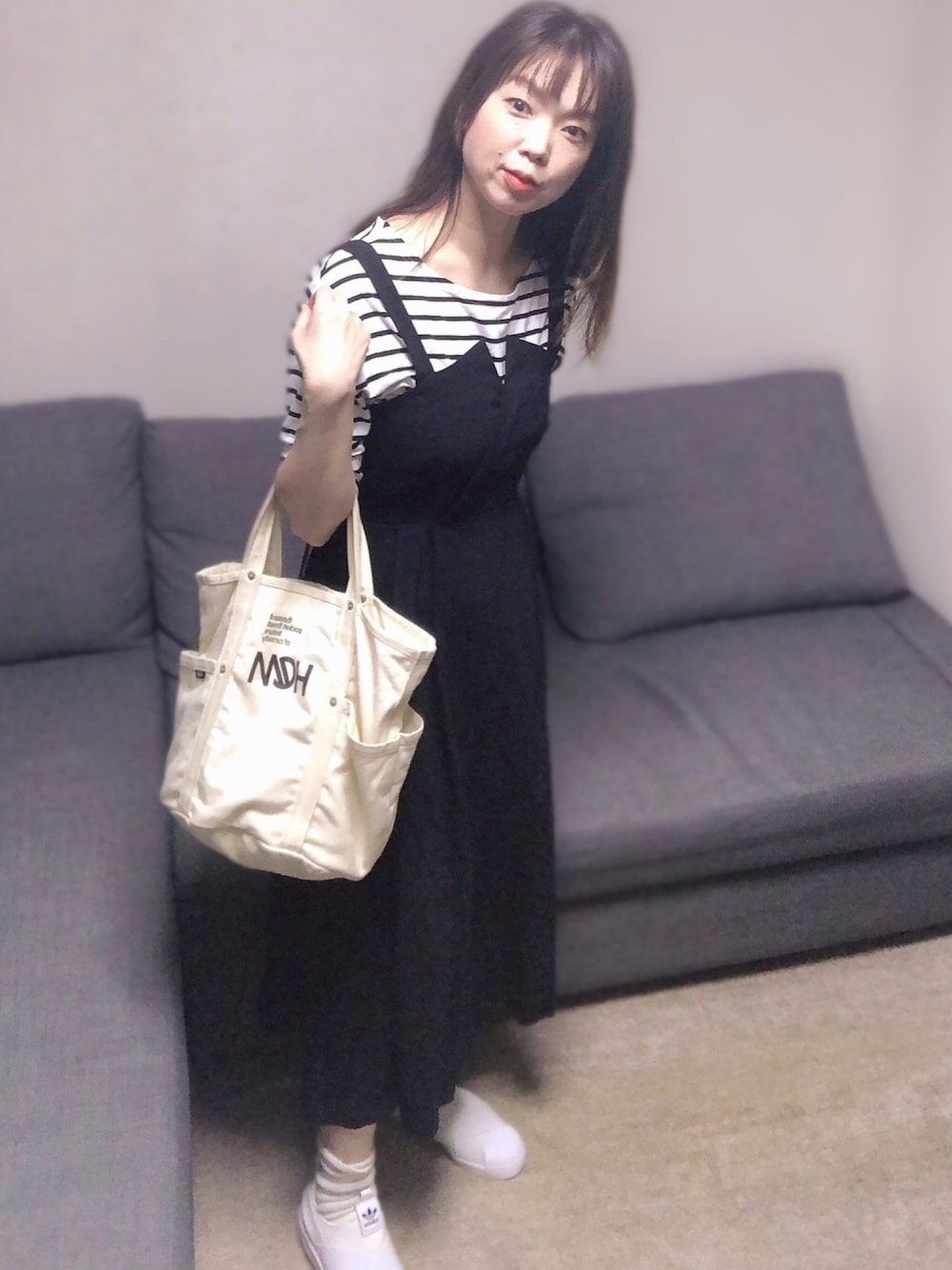 ブラック系のTシャツ/カットソー、ブラック系のワンピース、ホワイト系のスニーカーを着用したレディースの春コーディネートの1枚目の写真