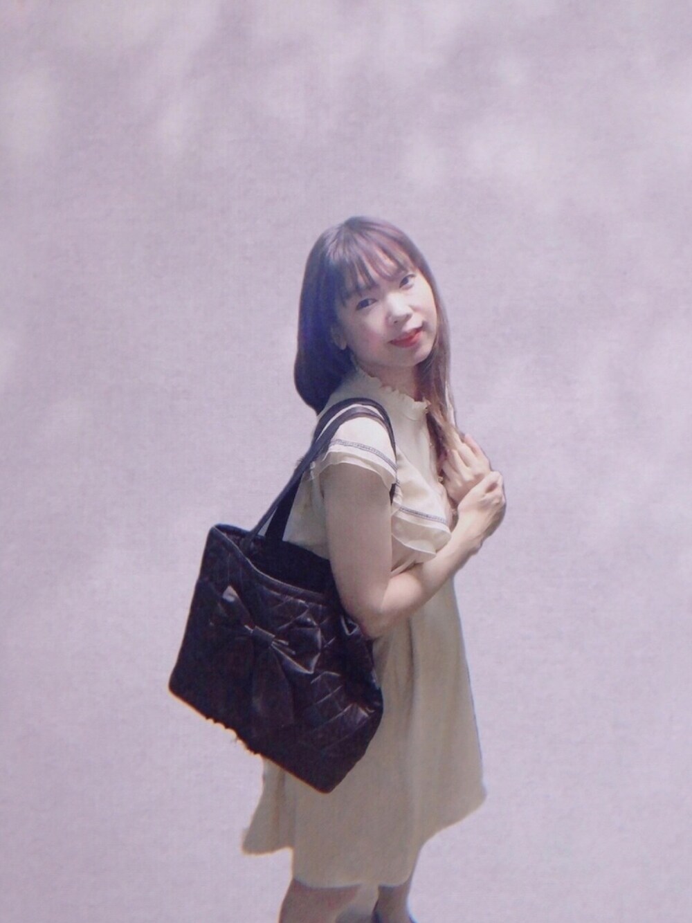 ベージュ系のワンピース、ブラック系のトートバッグ、ピンク系の財布を着用したレディースの夏コーディネートの1枚目の写真