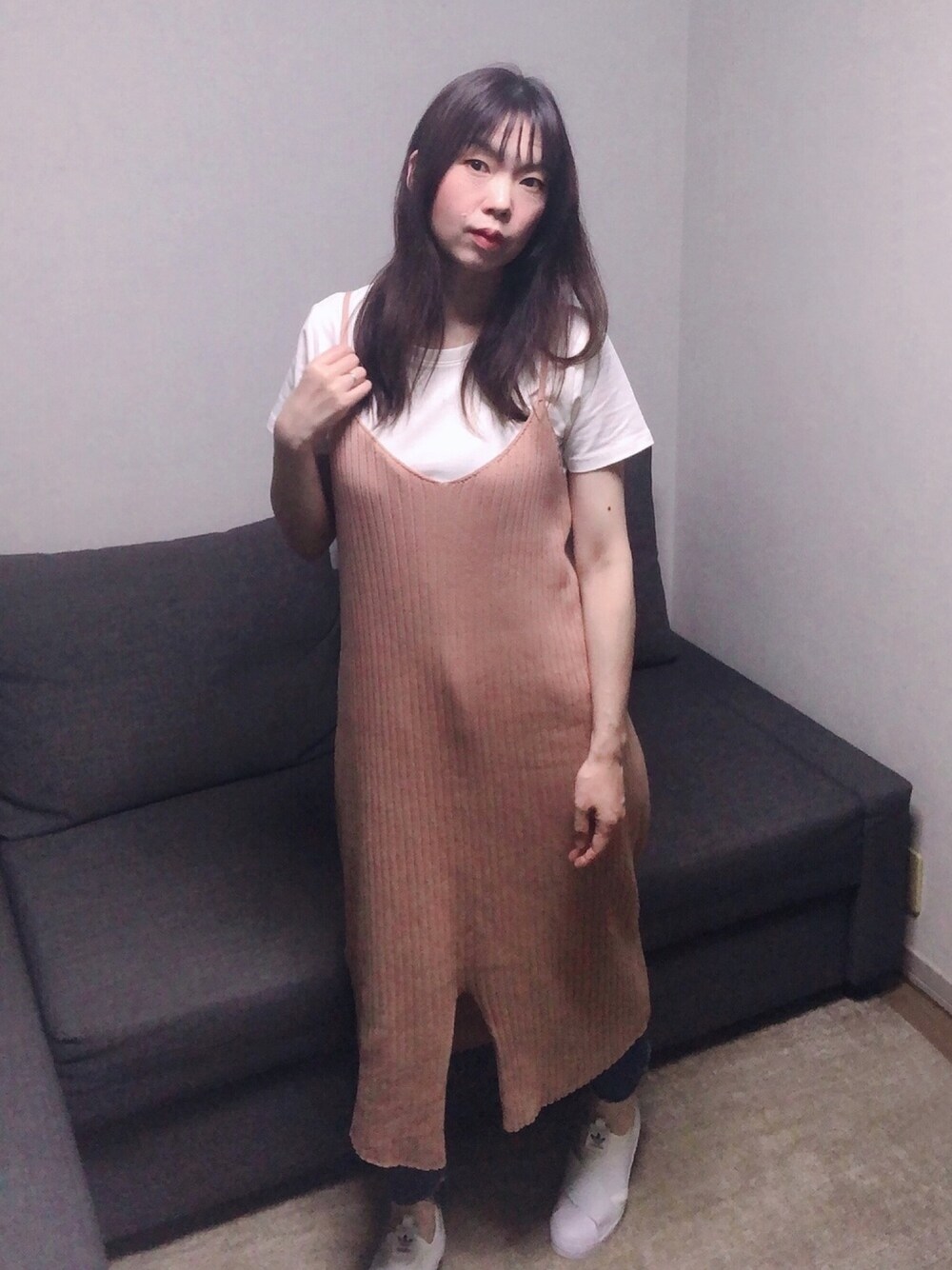 ピンク系のワンピース、ブルー系のデニムパンツ、ホワイト系のスニーカーを着用したレディースの夏コーディネートの1枚目の写真