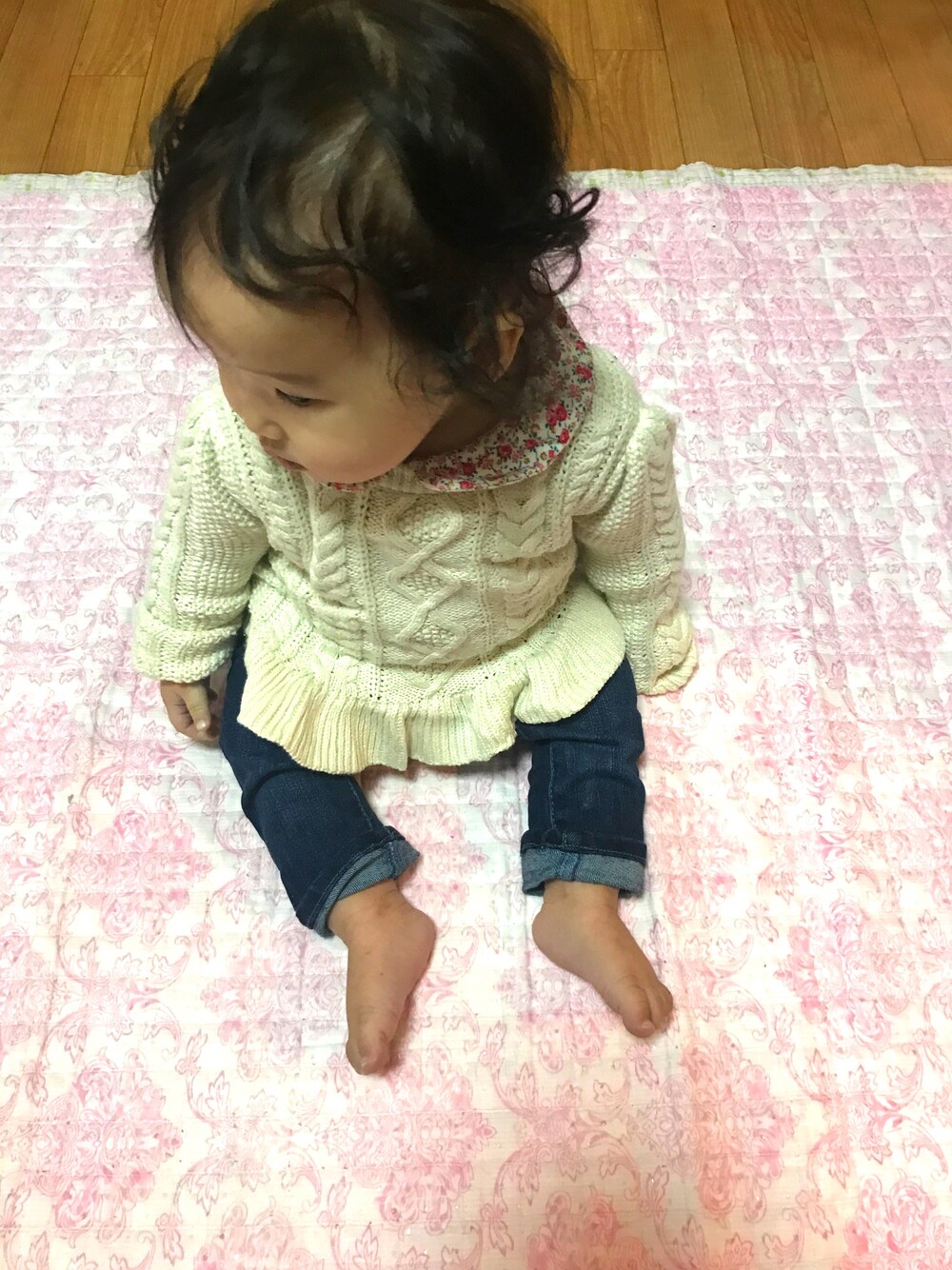 ホワイト系のニット/セーター、ブルー系のデニムパンツ、ピンク系のロンパースを着用したキッズの冬コーディネートの1枚目の写真