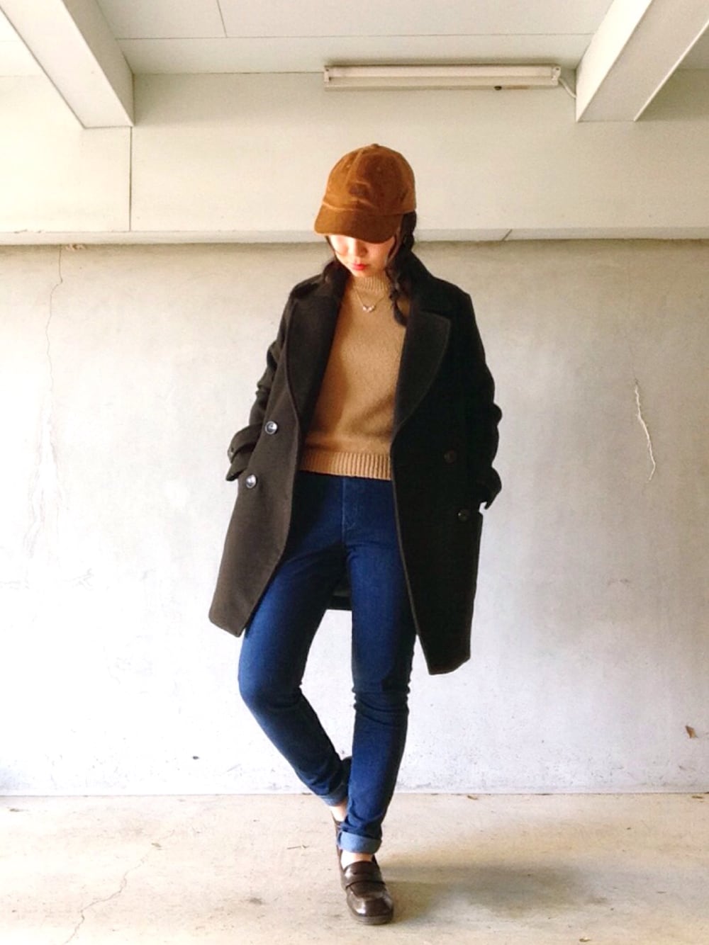 ブラック系のダウンジャケット/コート、ブルー系のデニムパンツ、ベージュ系のニット/セーターを着用したレディースの冬コーディネートの1枚目の写真