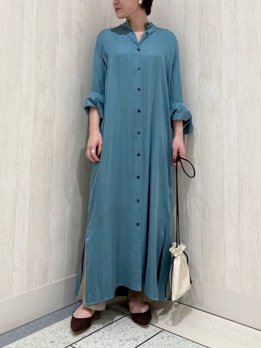 グリーン系のシャツワンピース、ホワイト系のハンドバッグ、ブラウン系のその他パンツを着用したレディースの秋コーディネートの1枚目の写真