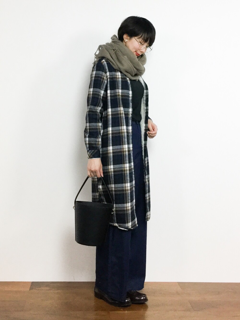 ブラウン系のシャツワンピース、ブルー系のデニムパンツ、ベージュ系のマフラーを着用したレディースの冬コーディネートの1枚目の写真