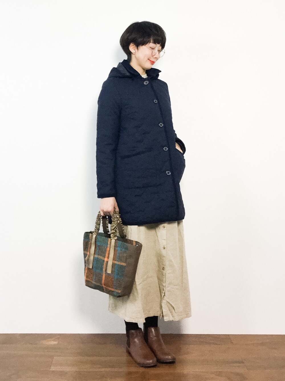 ブラウン系のトートバッグ、ベージュ系のスカート、ブルー系のブルゾンを着用したレディースの冬コーディネートの1枚目の写真