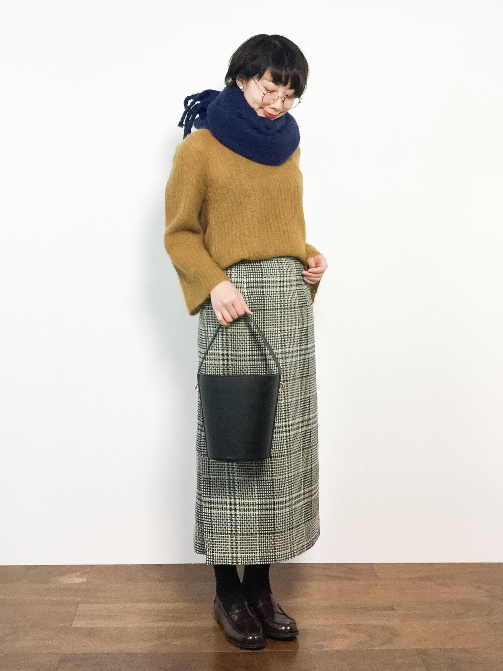 ブラック系のスカート、イエロー系のニット/セーターを着用したレディースの冬コーディネートの1枚目の写真