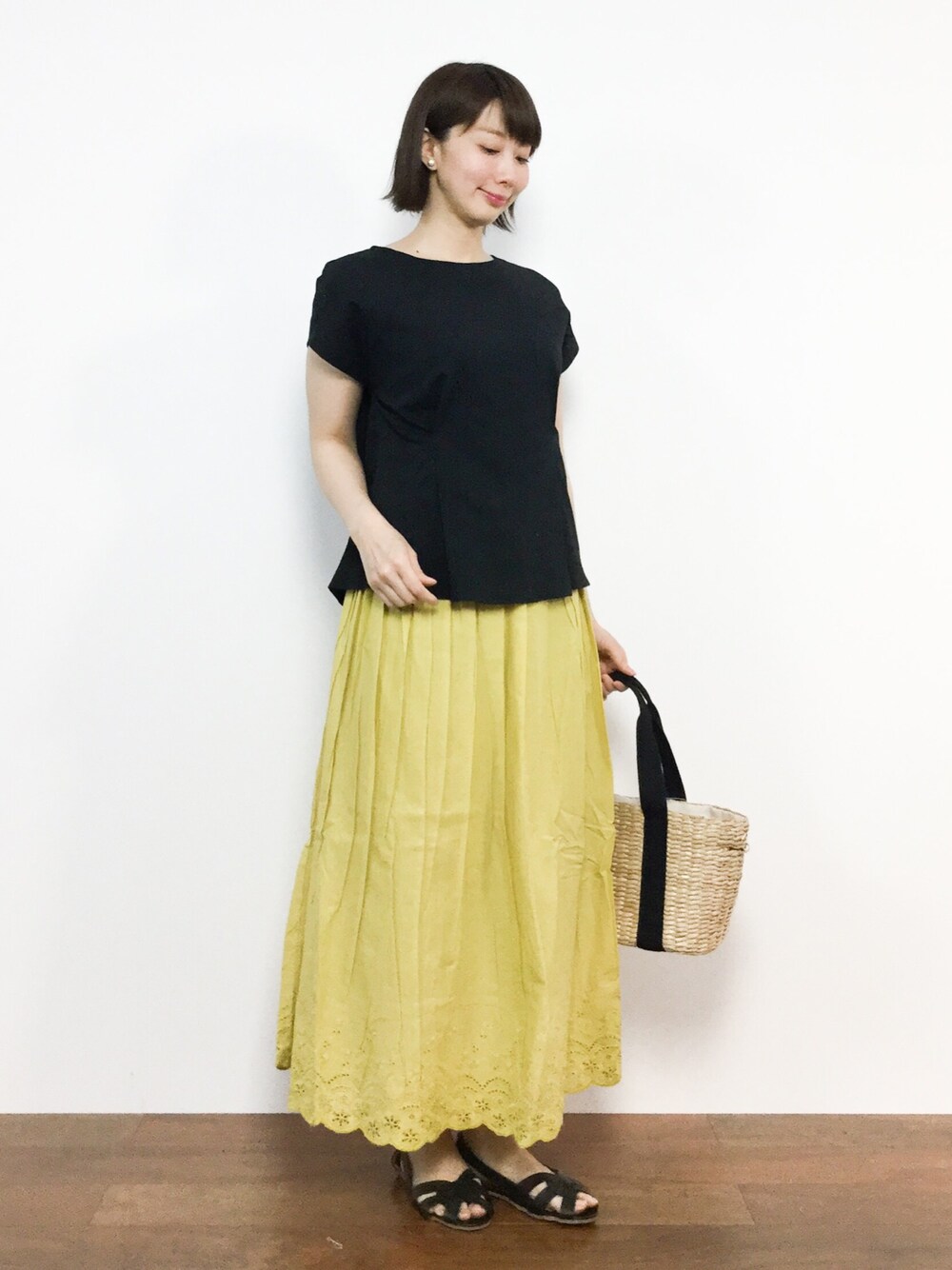 ブラック系のシャツ/ブラウス、イエロー系のスカートを着用したレディースの夏コーディネートの1枚目の写真