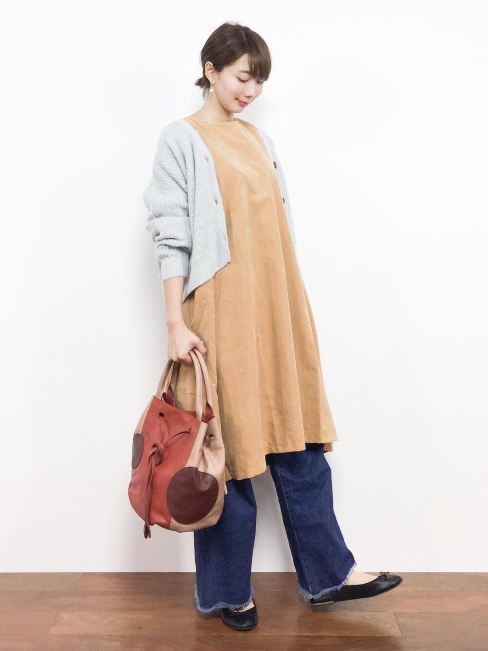 グレー系のカーディガン/ボレロ、イエロー系のワンピース、ブラウン系のハンドバッグを着用したレディースの秋コーディネートの1枚目の写真