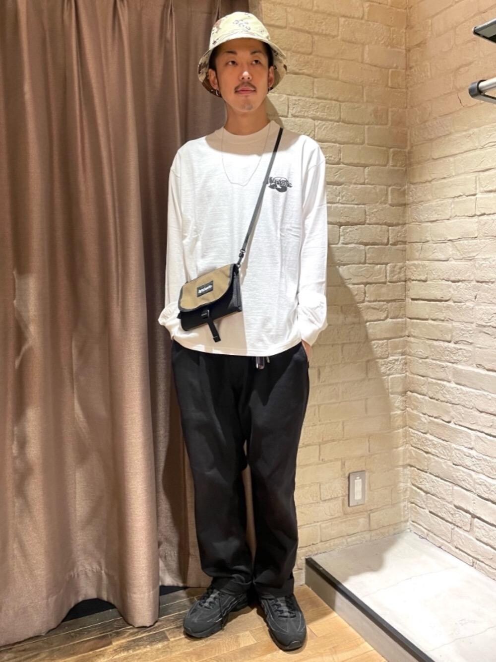 ブラウン系のボディバッグ/ウエストポーチ、ホワイト系のTシャツ/カットソー、ベージュ系のハットを着用したメンズの夏コーディネートの1枚目の写真