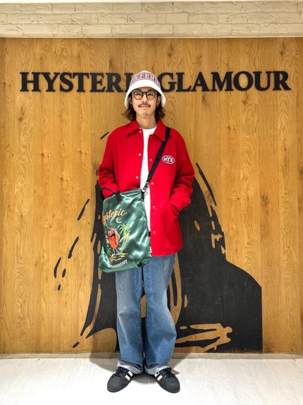 ブルー系のデニムパンツ、レッド系のブルゾン、グリーン系のショルダーバッグを着用したメンズの冬コーディネートの1枚目の写真