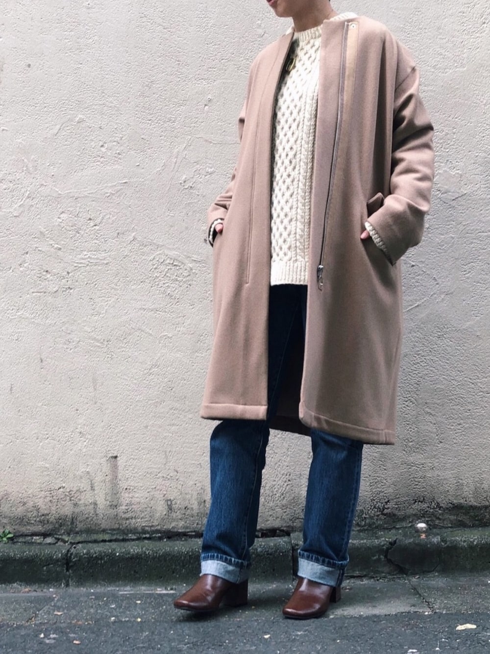 ベージュ系のモッズコート、ブルー系のデニムパンツ、ホワイト系のニット/セーターを着用したレディースの冬コーディネートの1枚目の写真