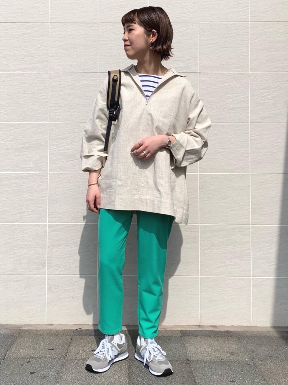 グリーン系のその他パンツ、その他のTシャツ/カットソー、グレー系のスニーカーを着用したレディースの春コーディネートの1枚目の写真