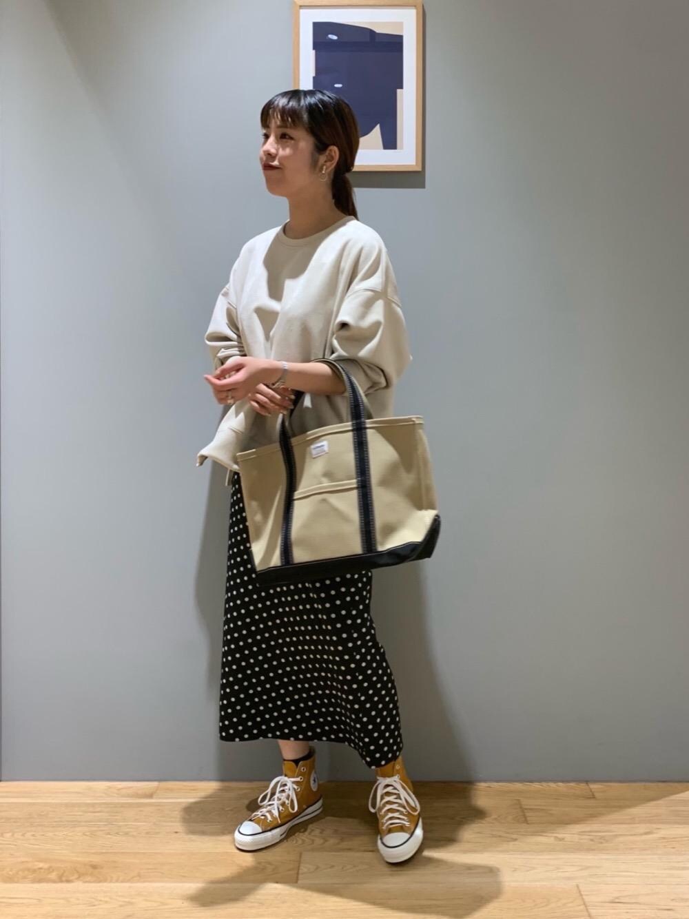 ブラウン系のショルダーバッグ、ベージュ系のTシャツ/カットソー、ブラック系のスカートを着用したレディースの夏コーディネートの1枚目の写真