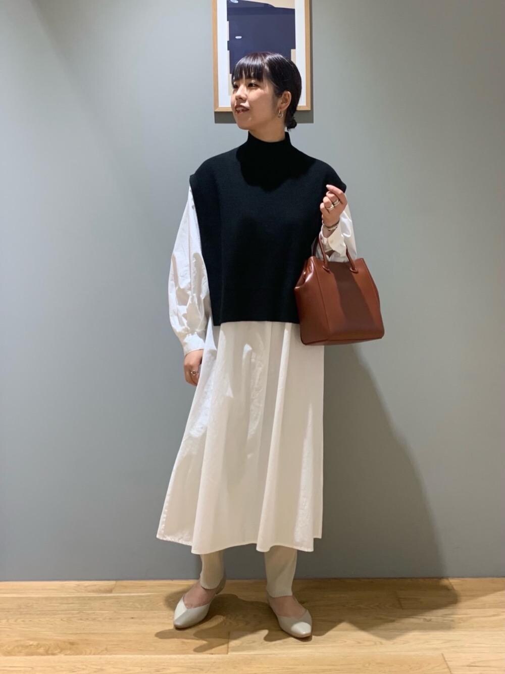 ベージュ系のスカート、ホワイト系のワンピース、ベージュ系のパンプスを着用したレディースの秋コーディネートの1枚目の写真