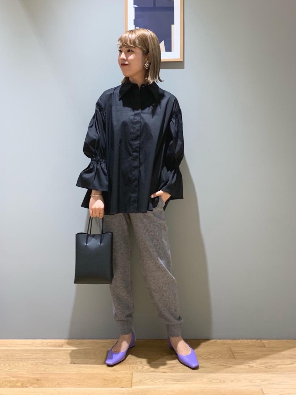 ブラック系のショルダーバッグ、パープル系のパンプス、グレー系のその他パンツを着用したレディースの秋コーディネートの1枚目の写真