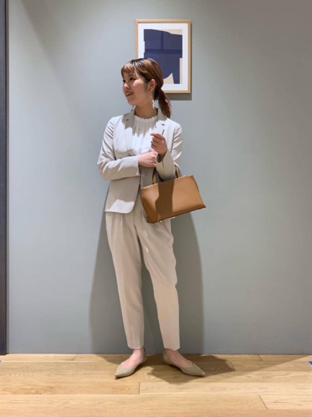 ブラウン系のトートバッグ、ベージュ系のテーラードジャケット、ベージュ系のその他パンツを着用したレディースの冬コーディネートの1枚目の写真