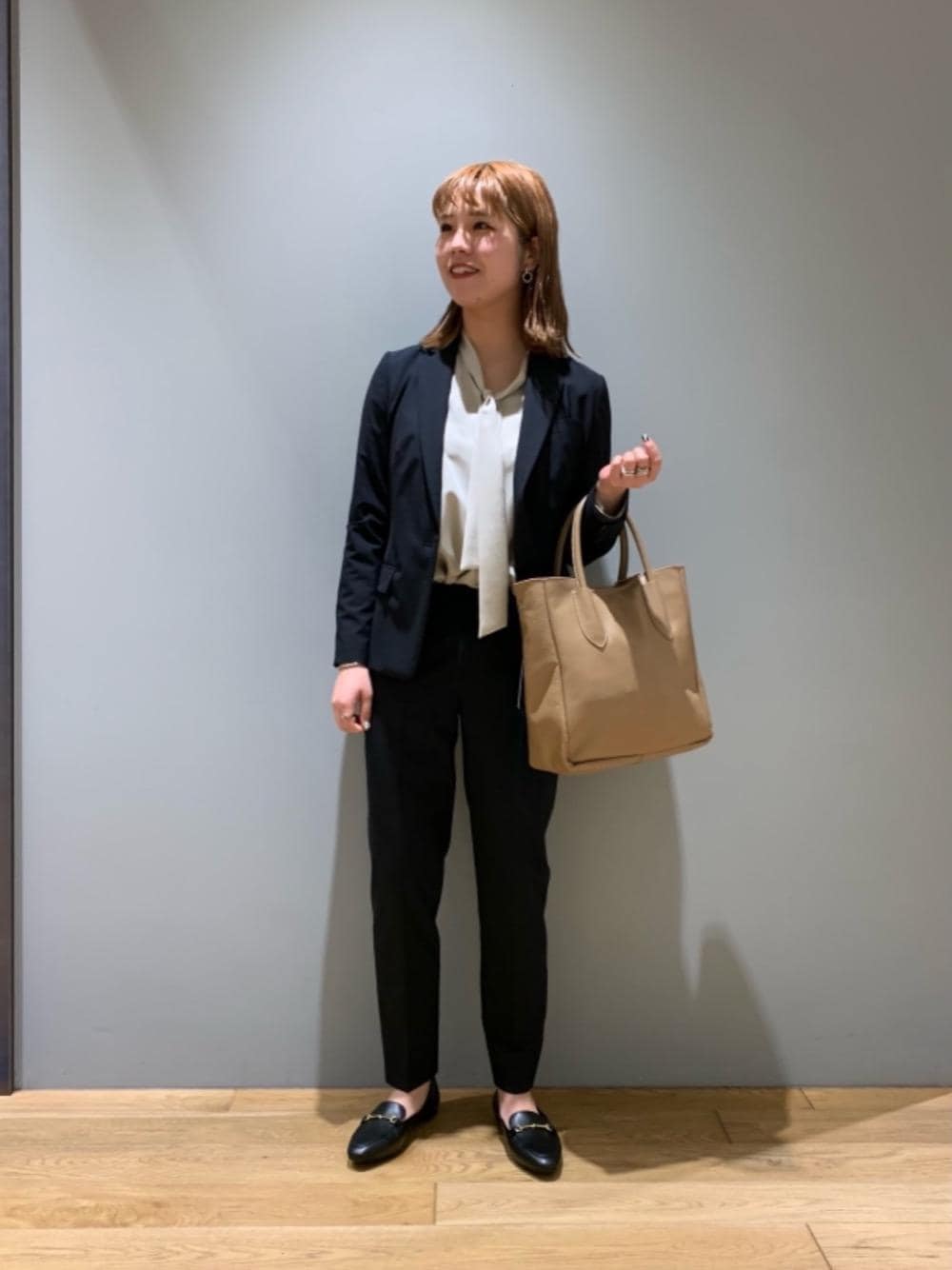 ベージュ系のシャツ/ブラウス、ブラック系のローファー、ベージュ系のトートバッグを着用したレディースの冬コーディネートの1枚目の写真
