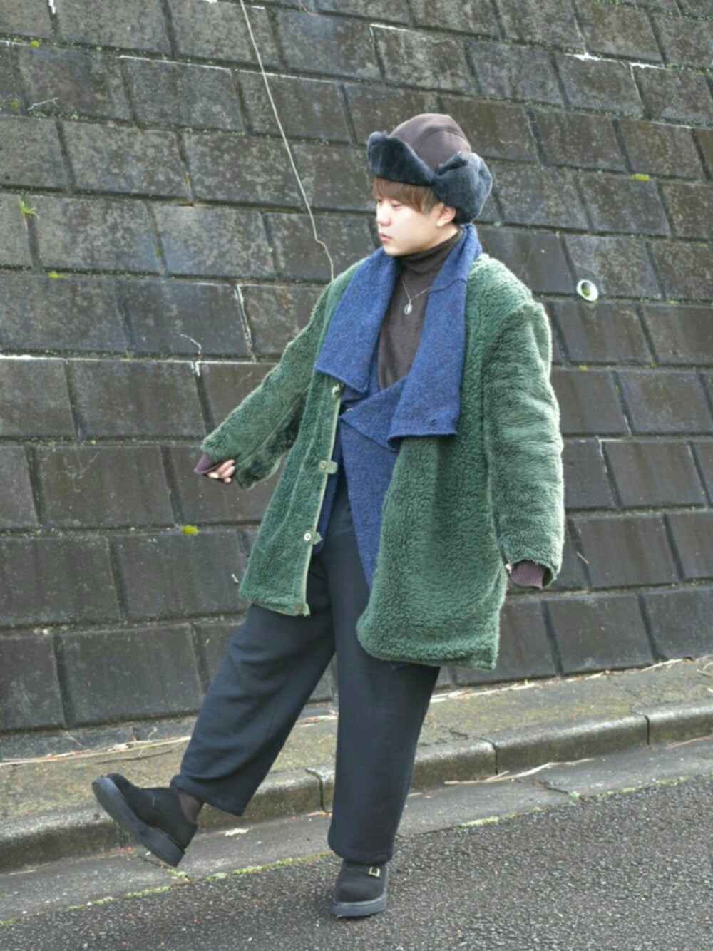 グリーン系のジャケット/アウター、ブルー系のニット/セーター、ブラウン系のニット/セーターを着用したメンズの冬コーディネートの1枚目の写真