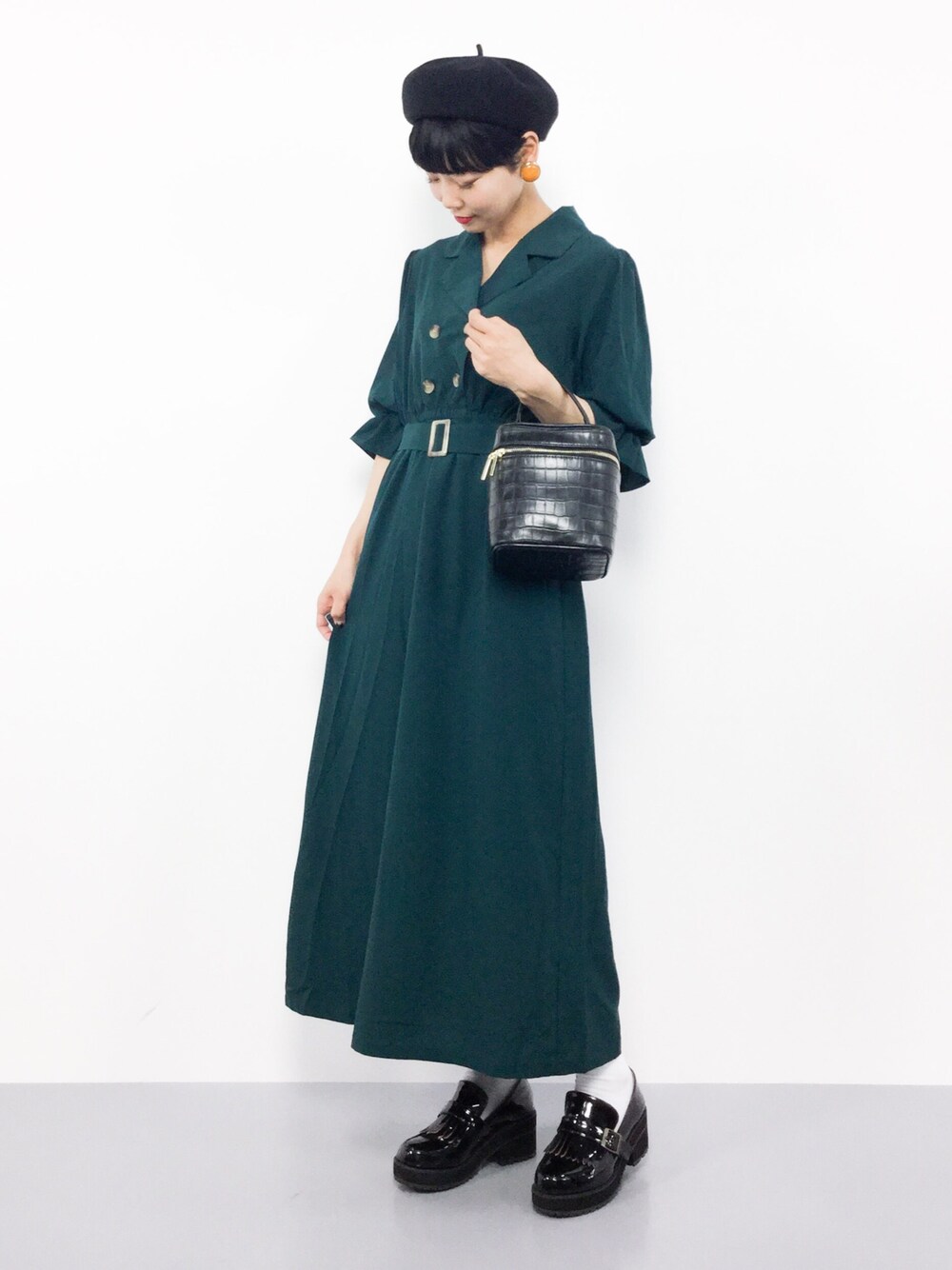 グリーン系のワンピース、ブラック系のショルダーバッグを着用したレディースの夏コーディネートの1枚目の写真