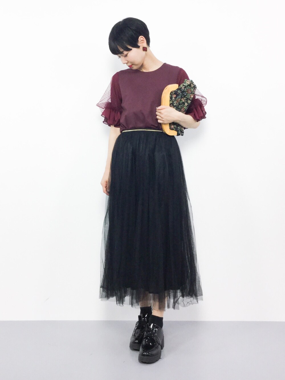 ブラック系のスカート、レッド系のTシャツ/カットソー、ブラック系のショルダーバッグを着用したレディースの夏コーディネートの1枚目の写真