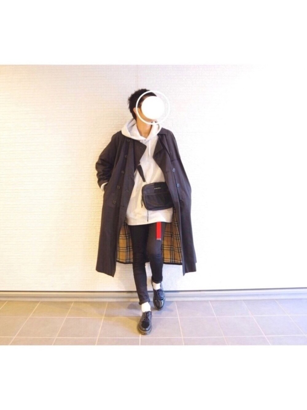 ブラック系のトレンチコート、グレー系のパーカー、ブラック系のショルダーバッグを着用したメンズの冬コーディネートの1枚目の写真