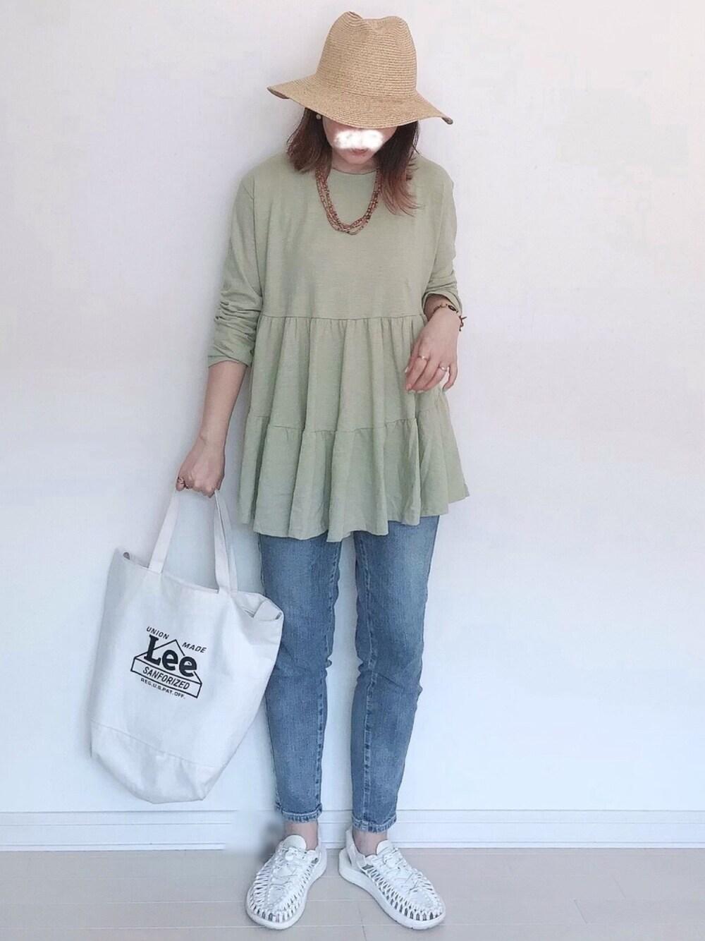 ブルー系のデニムパンツ、グリーン系のTシャツ/カットソー、ホワイト系のトートバッグを着用したレディースの春コーディネートの1枚目の写真