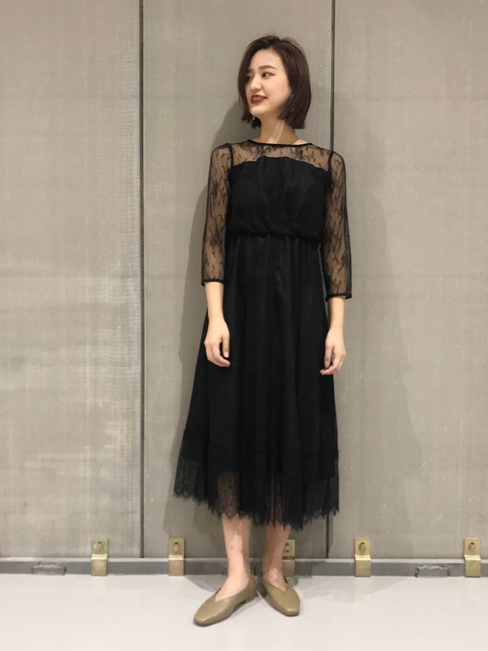 ブラック系のドレス、グリーン系のパンプスを着用したレディースの春コーディネートの1枚目の写真