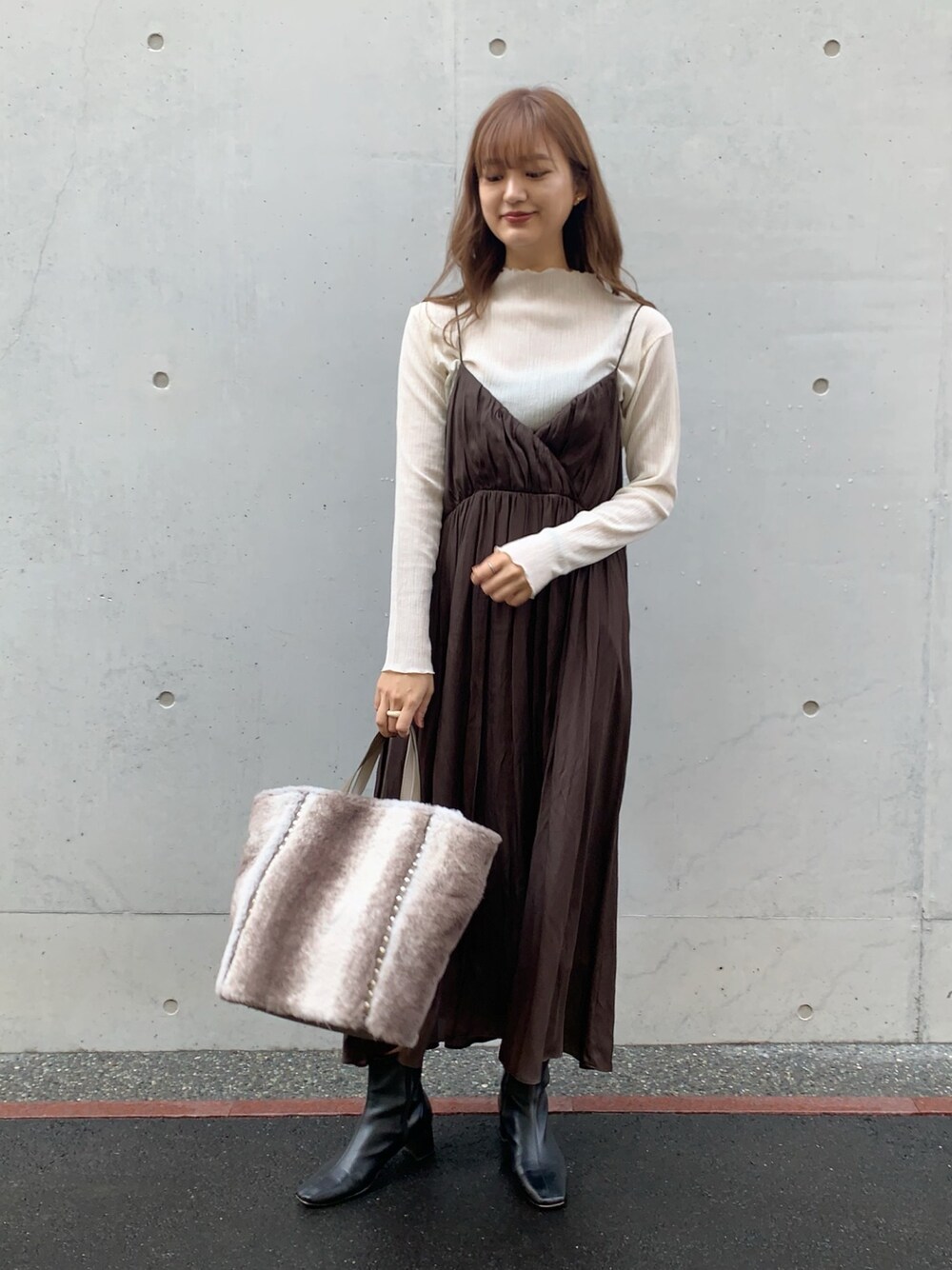 ブラウン系のワンピース、ブラウン系のトートバッグ、ホワイト系のTシャツ/カットソーを着用したレディースの秋コーディネートの1枚目の写真