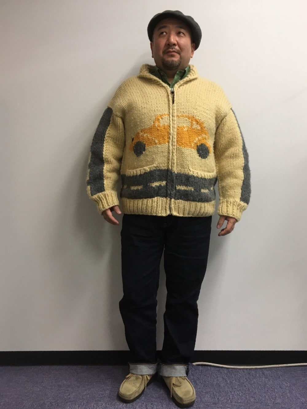 ベージュ系のカーディガン/ボレロ、ブルー系のデニムパンツ、ベージュ系のモカシン/デッキシューズを着用したメンズの秋コーディネートの1枚目の写真