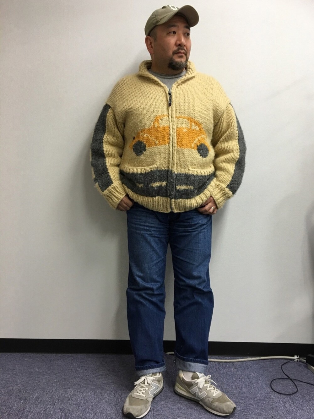 ベージュ系のカーディガン/ボレロ、グレー系のスウェット、ブルー系のデニムパンツを着用したメンズの春コーディネートの1枚目の写真