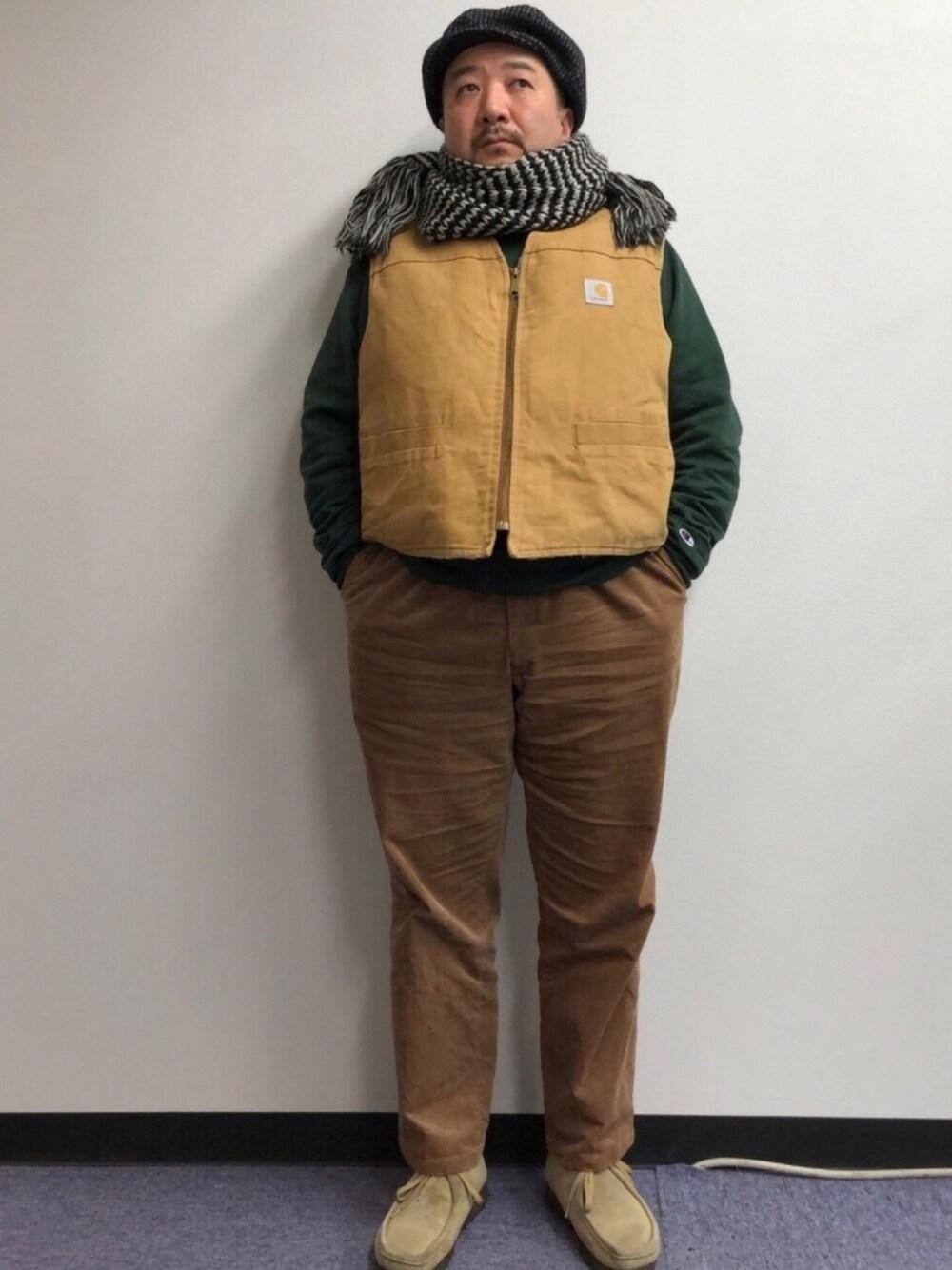 ベージュ系のベスト、グリーン系のスウェット、ブラウン系のその他パンツを着用したメンズの春コーディネートの1枚目の写真