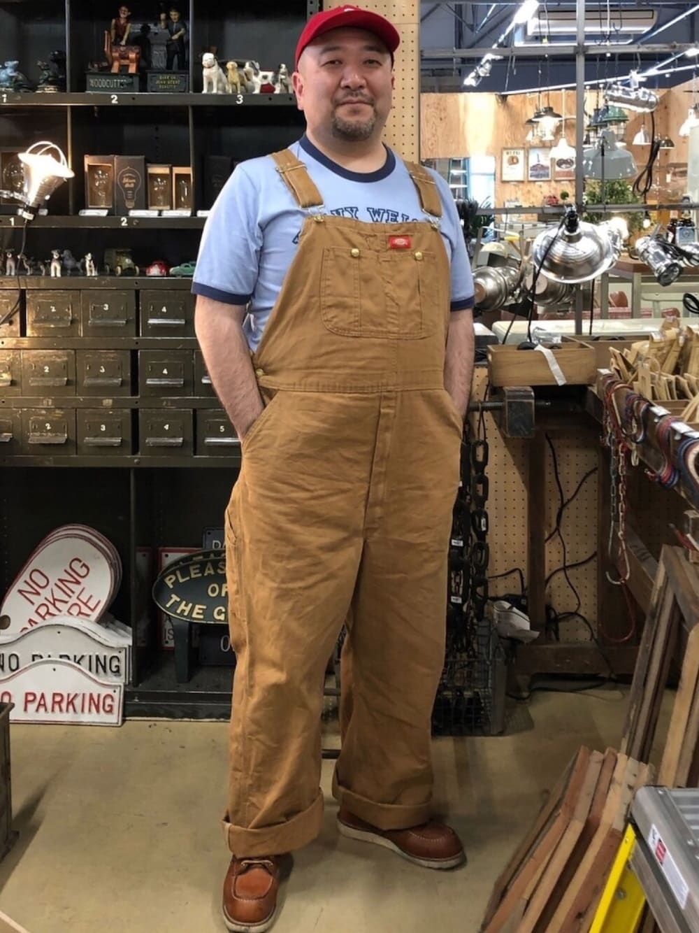 ブラウン系のサロペット/オーバーオール、ブラウン系のブーツ、ブルー系のTシャツ/カットソーを着用したメンズの春コーディネートの1枚目の写真