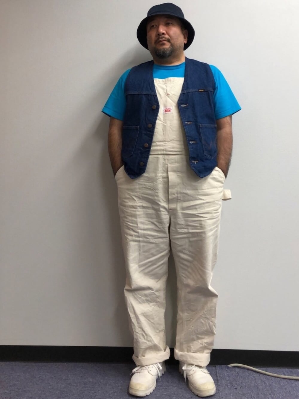 ブルー系のベスト、ブルー系のTシャツ/カットソー、ホワイト系のサロペット/オーバーオールを着用したメンズの夏コーディネートの1枚目の写真