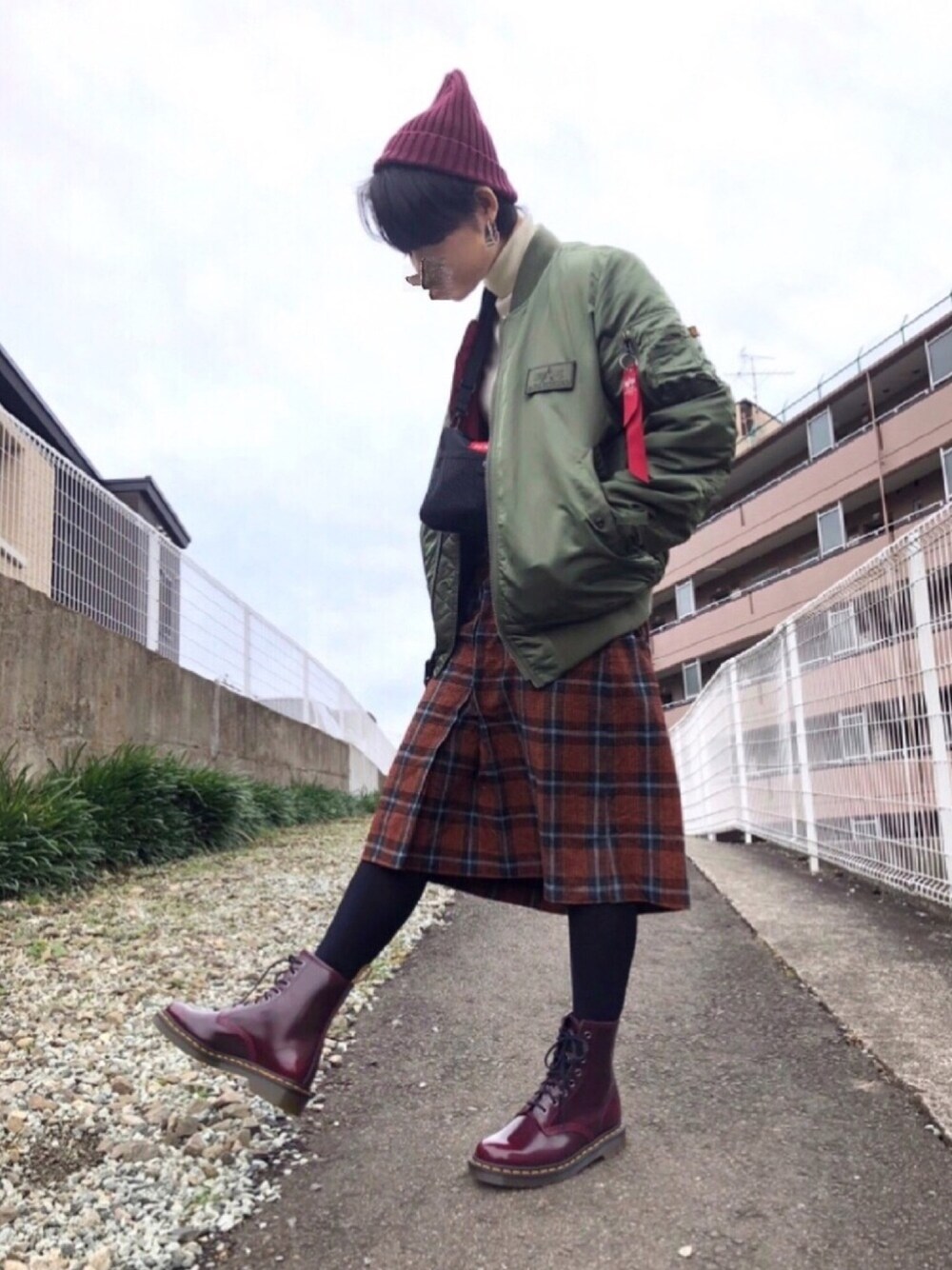 ホワイト系のニット/セーター、ブラック系のボディバッグ/ウエストポーチ、グリーン系のMA-1を着用したレディースの冬コーディネートの1枚目の写真