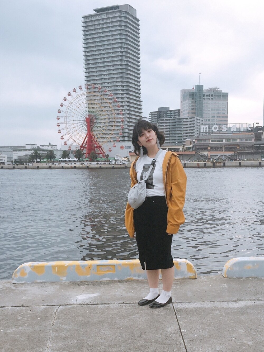 ホワイト系のショルダーバッグ、ブラック系のスカート、イエロー系のジャケット/アウターを着用したレディースの秋コーディネートの1枚目の写真