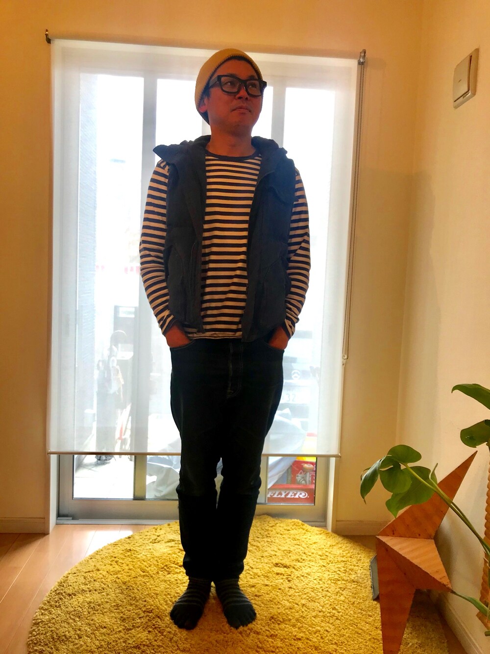 ブラック系のTシャツ/カットソー、ブラック系のデニムパンツ、ブルー系のベストを着用したメンズの春コーディネートの1枚目の写真