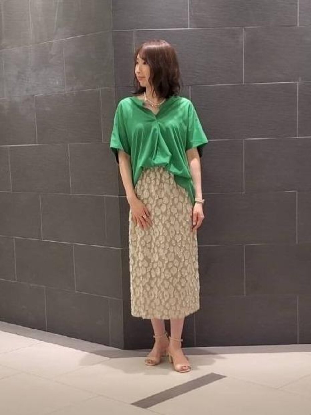 ベージュ系のサンダル、ベージュ系のスカート、グリーン系のシャツ/ブラウスを着用したレディースの夏コーディネートの1枚目の写真