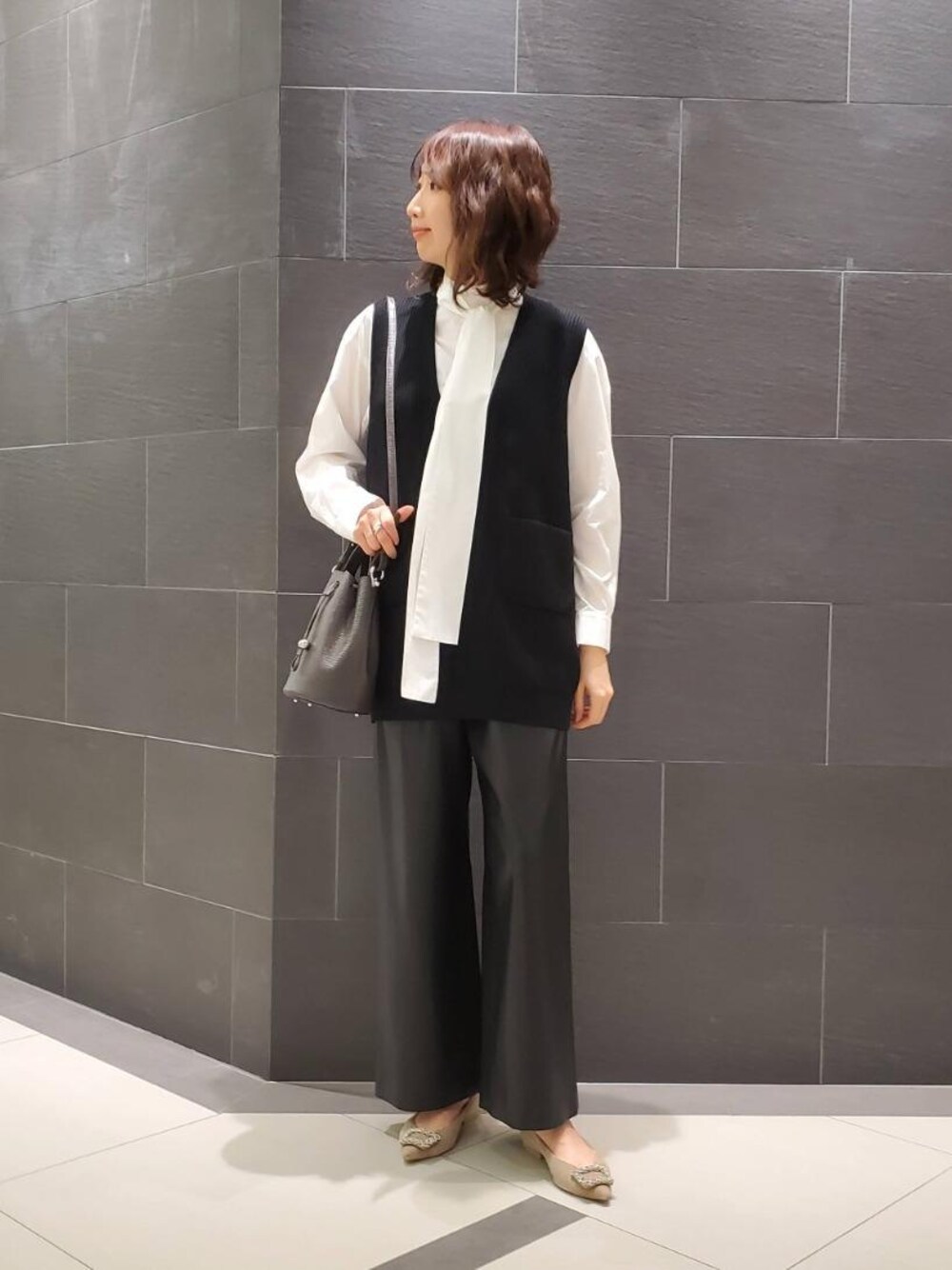 ブラウン系のショルダーバッグ、ブラック系のその他パンツ、ホワイト系のシャツ/ブラウスを着用したレディースの秋コーディネートの1枚目の写真