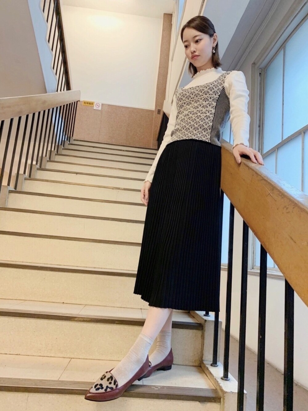 レッド系のパンプスを着用したレディースの秋コーディネートの1枚目の写真