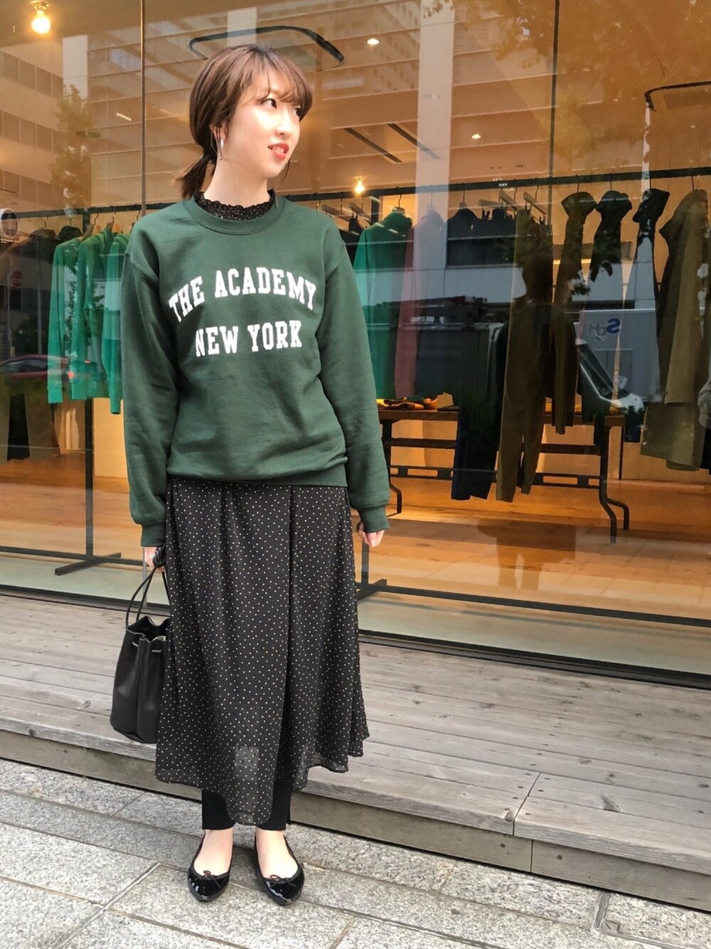 グリーン系のスウェット、ブラック系のワンピース、ブラック系のバレエシューズを着用したレディースの秋コーディネートの1枚目の写真