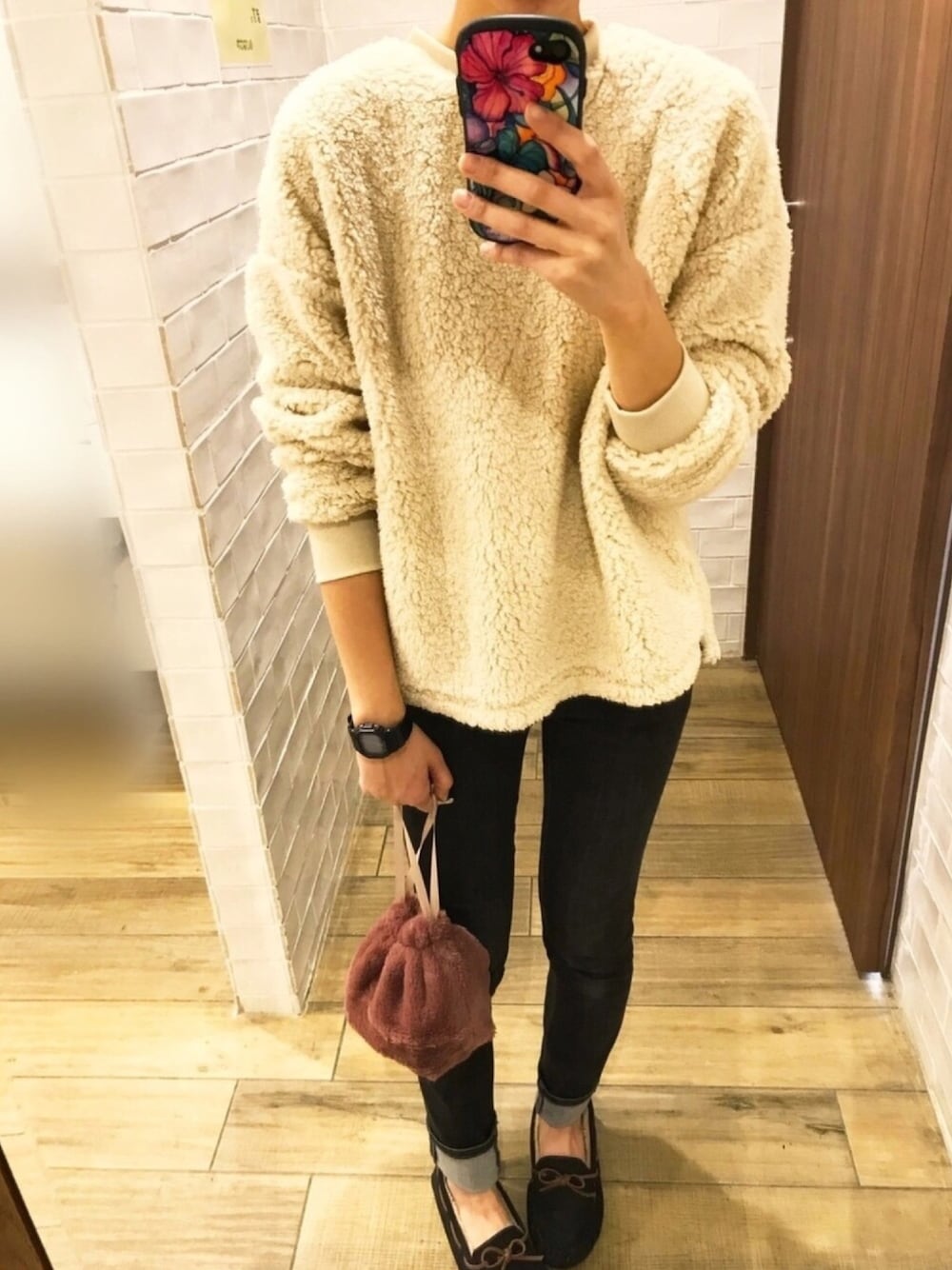 ベージュ系のトップス、ピンク系のバッグ、ブラック系のデニムパンツを着用したレディースの秋コーディネートの1枚目の写真