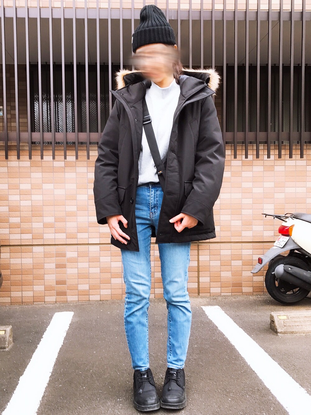 ブラック系のダウンベスト、ブルー系のデニムパンツ、ブラック系のシューズを着用したレディースの冬コーディネートの1枚目の写真