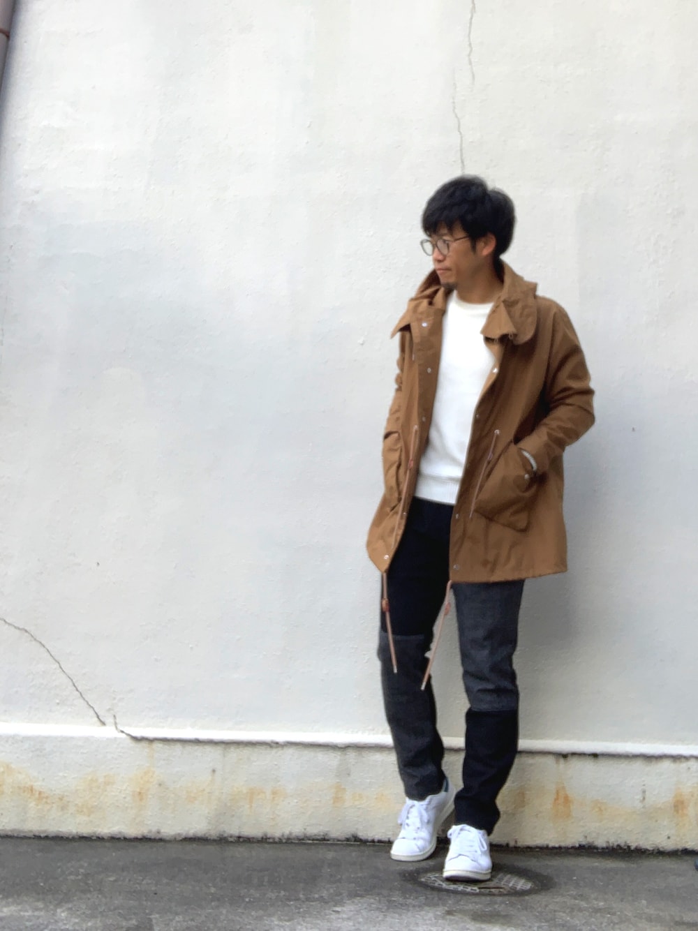 イエロー系のモッズコート、ホワイト系のニット/セーター、ブラック系のその他パンツを着用したメンズの春コーディネートの1枚目の写真