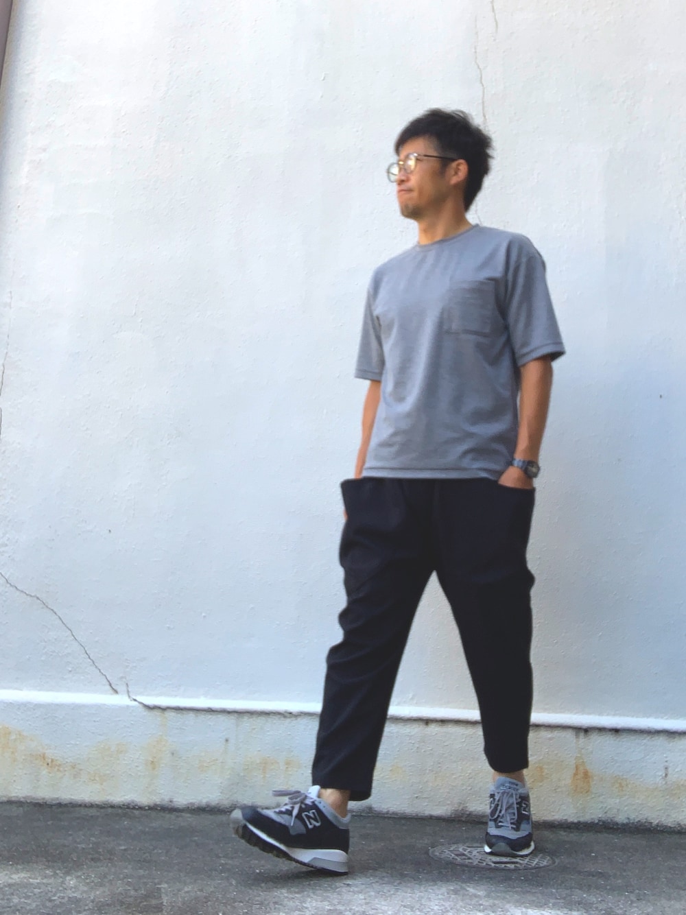 ブラック系のその他パンツ、グレー系のTシャツ/カットソー、グレー系のスニーカーを着用したメンズの秋コーディネートの1枚目の写真