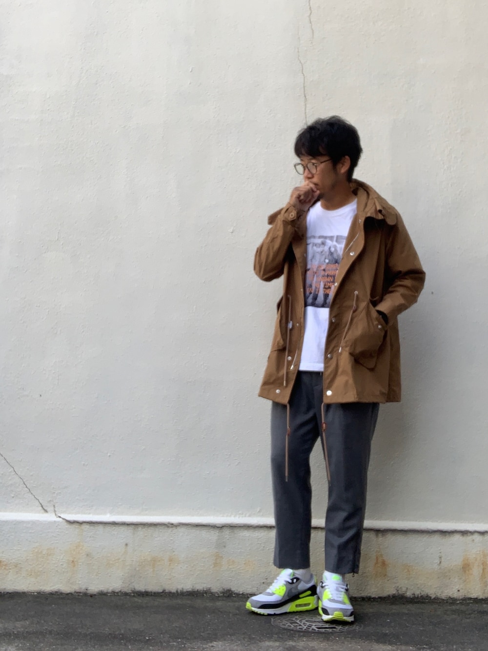 イエロー系のモッズコート、ホワイト系のTシャツ/カットソー、グレー系のその他パンツを着用したメンズの秋コーディネートの1枚目の写真