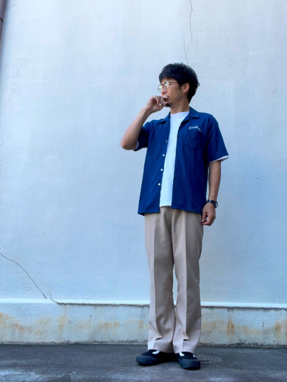 ブルー系のシャツ/ブラウス、ベージュ系のスラックス、ブラック系のスニーカーを着用したメンズの夏コーディネートの1枚目の写真