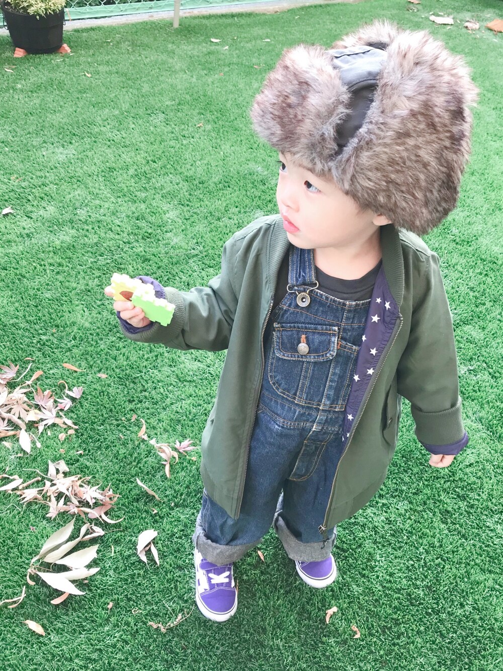 「2歳3ヶ月、おとこのこ、キッズファッション、年末WEAR感謝祭、秋冬コーデ、カーキ、フライトキャップ、MA-1、落ち葉ちぎって遊ぶ」｜「B:MING by BEAMSのROTHCO / ファー フライヤーハット（キャップ、グリーン系）」を使った、モリコさん（キッズ・80cm）の冬コーディネートの1枚目の写真