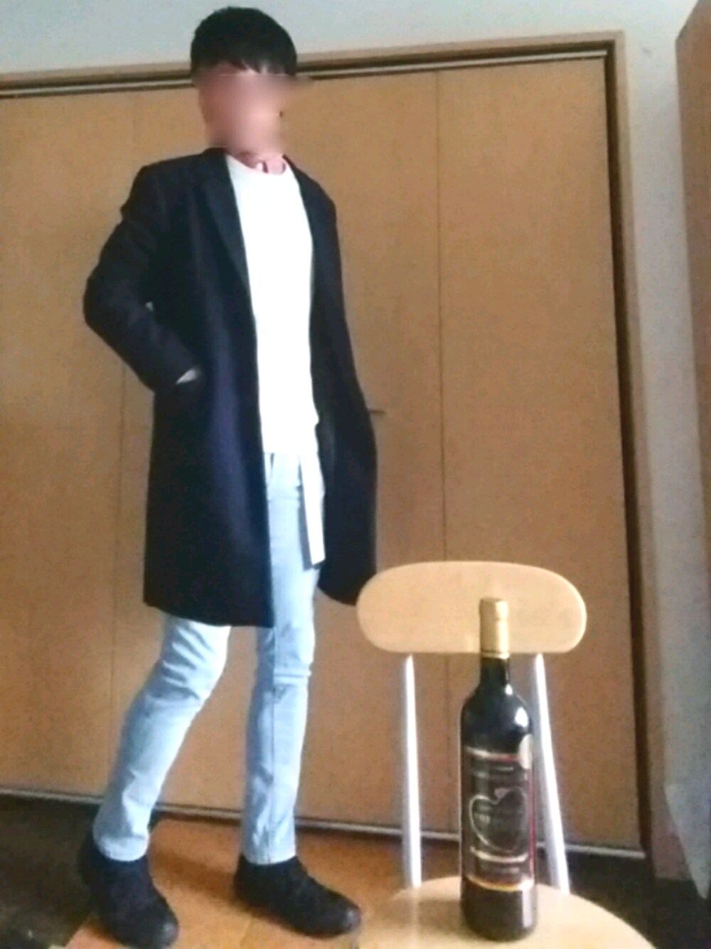 ブルー系のデニムパンツ、ブラック系のスニーカー、ブルー系のチェスターコートを着用したメンズの秋コーディネートの1枚目の写真