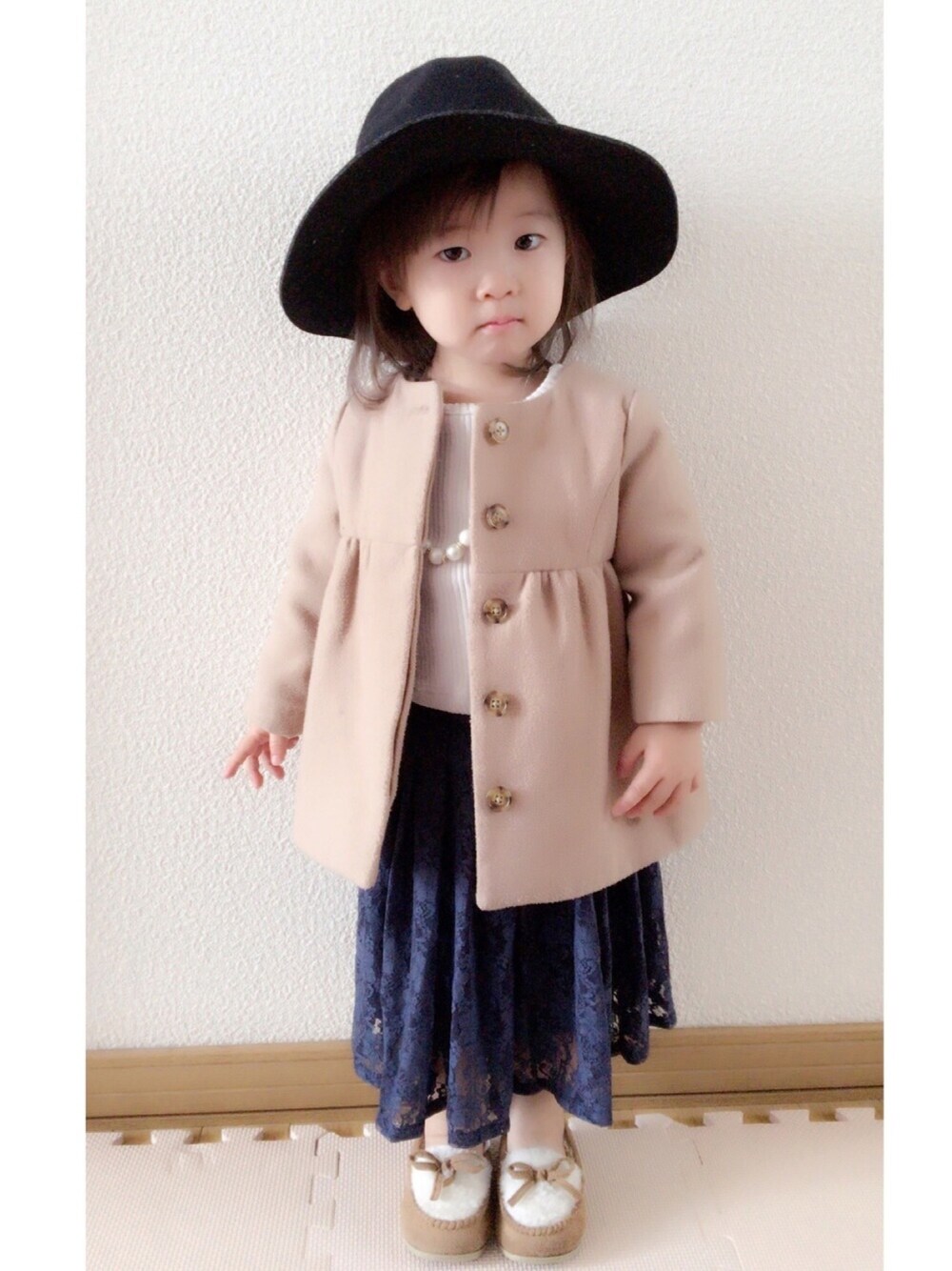 ベージュ系のジャケット/アウター、ホワイト系のTシャツ/カットソー、ブルー系のスカートを着用したキッズの冬コーディネートの1枚目の写真